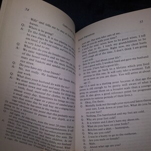 Puede incluir: Una fotograf&iacute;a en blanco y negro de un libro abierto en una p&aacute;gina con texto sobre la vida de una mujer y el trabajo de su marido. El texto incluye preguntas y respuestas sobre su rutina diaria y su vida familiar.