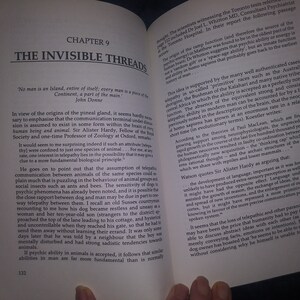 May include: Open book with a white background. The book is open to a chapter titled "The Invisible Threads." The text on the page discusses the origins of the pineal gland and the possibility of telepathy in animals. The book is part of a larger collection about the history of man.