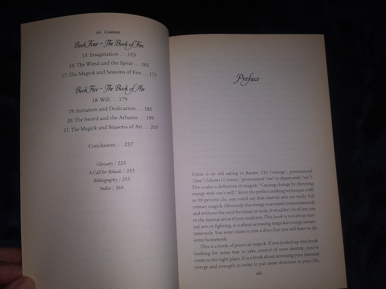 May include: A close-up of a book titled "Book Five - The Book of Air" with a preface that discusses the concept of "chi" or energy in martial arts and how it relates to magick. The book is about accessing internal energy and strength to direct your life.