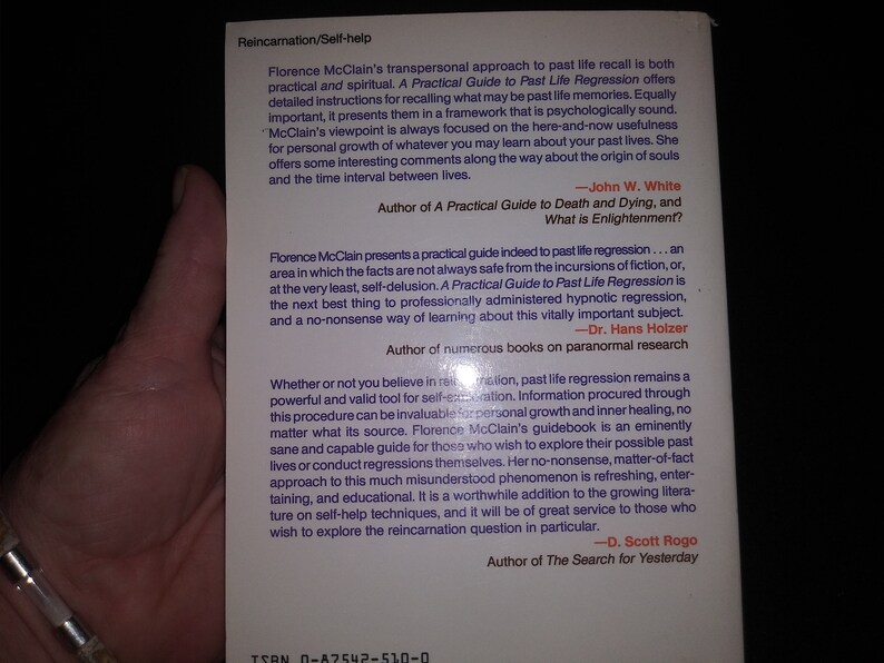 May include: Book cover with a white background and black text. The title of the book is "A Practical Guide to Past Life Regression". The book is about reincarnation and self-help. The back cover features quotes from other authors about the book.
