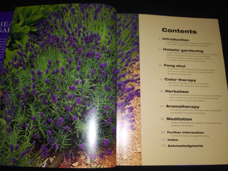 May include: A book titled "The Healing Garden" with a table of contents listing topics such as holistic gardening, feng shui, color therapy, herbalism, aromatherapy, and meditation.