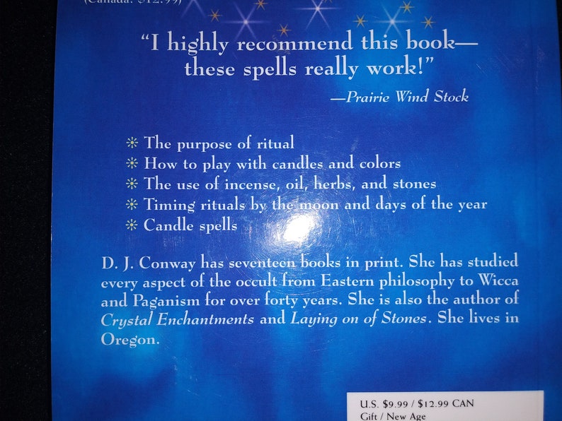 May include: A book cover with a blue background and white text. The text includes a recommendation for the book, a list of topics such as rituals and spells, and author information. The book is about Wicca and Paganism.