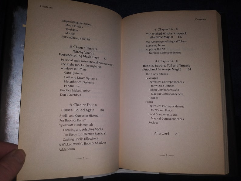 May include: A book titled "The Wicked Witch's Grimoire" with a table of contents listing chapters on topics such as fortune-telling, curses, portable magic, and food and beverage magic.