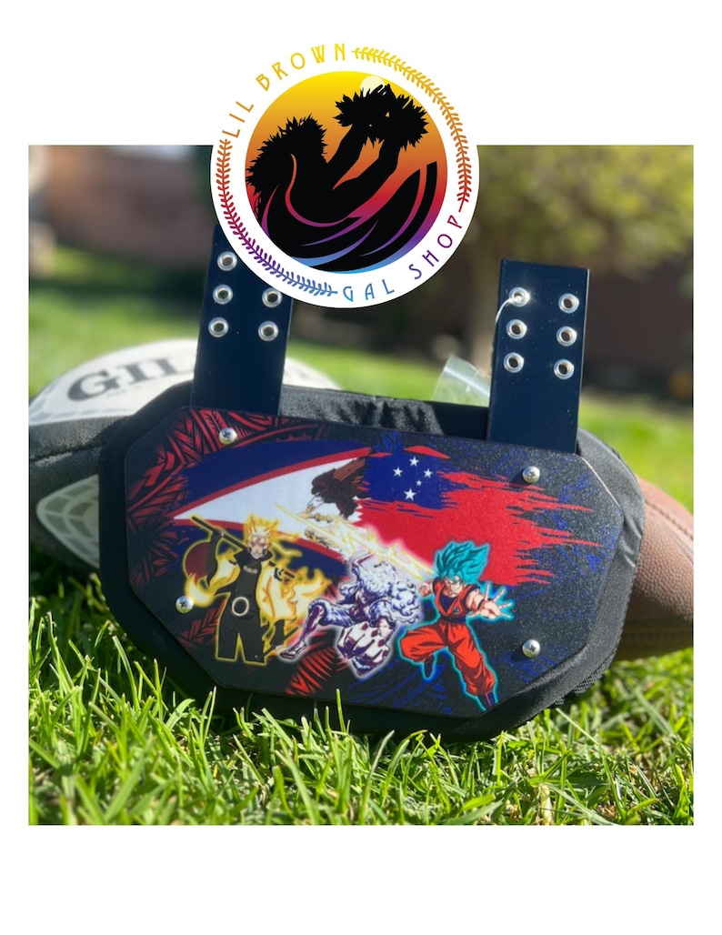 May include: A black football back plate featuring a graphic print of anime characters, including a yellow-haired figure and a blue-haired figure, set against a red and blue background with a Samoan flag design and two vertical attachment straps.
