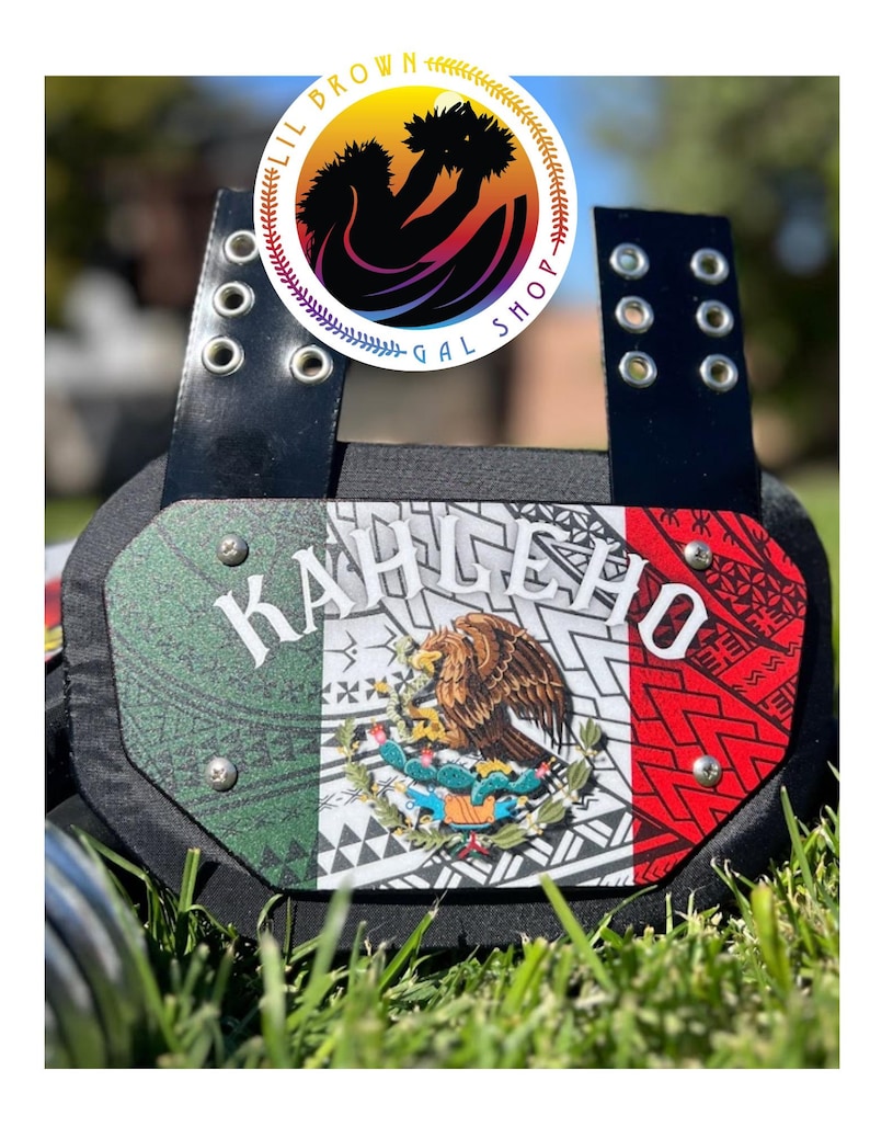 May include: A black football back plate featuring a central panel with the Mexican flag colors of green, white, and red, overlaid with a tribal pattern and the Mexican coat of arms. The text KAHLEHO is printed in white across the top center.