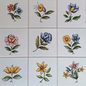 May include: Nine square tiles with hand-painted floral designs. Each tile features a different flower in shades of blue, yellow, pink, and red.