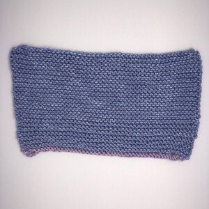 Może przedstawiać: Prostokątny element dzianiny w jasnoniebieskim kolorze z jasnofioletowym obramowaniem.