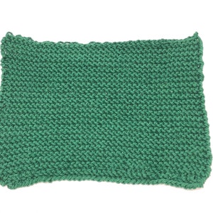 Może przedstawiać: Zielony dzianinowy ściereczka do naczyń lub ręcznik kuchenny. Ściereczka jest wykonana prostym ściegiem dzianinowym i ma lekko fakturowaną powierzchnię.