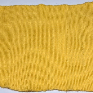 Może przedstawiać: Próbka żółtej dzianiny. Tkanina ma drobną strukturę dzianiny.