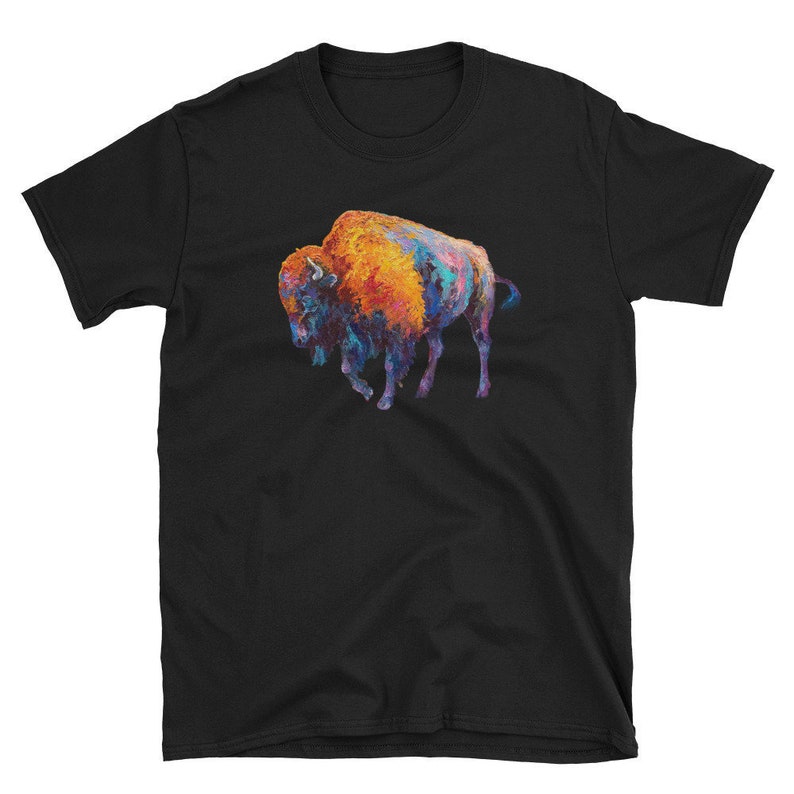 May include: A black t-shirt with a colorful illustration of a bison. The bison is painted in shades of orange, yellow, blue, and purple.