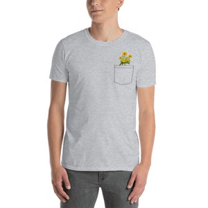 May include: A gray t-shirt with a pocket featuring a small bouquet of yellow sunflowers.
