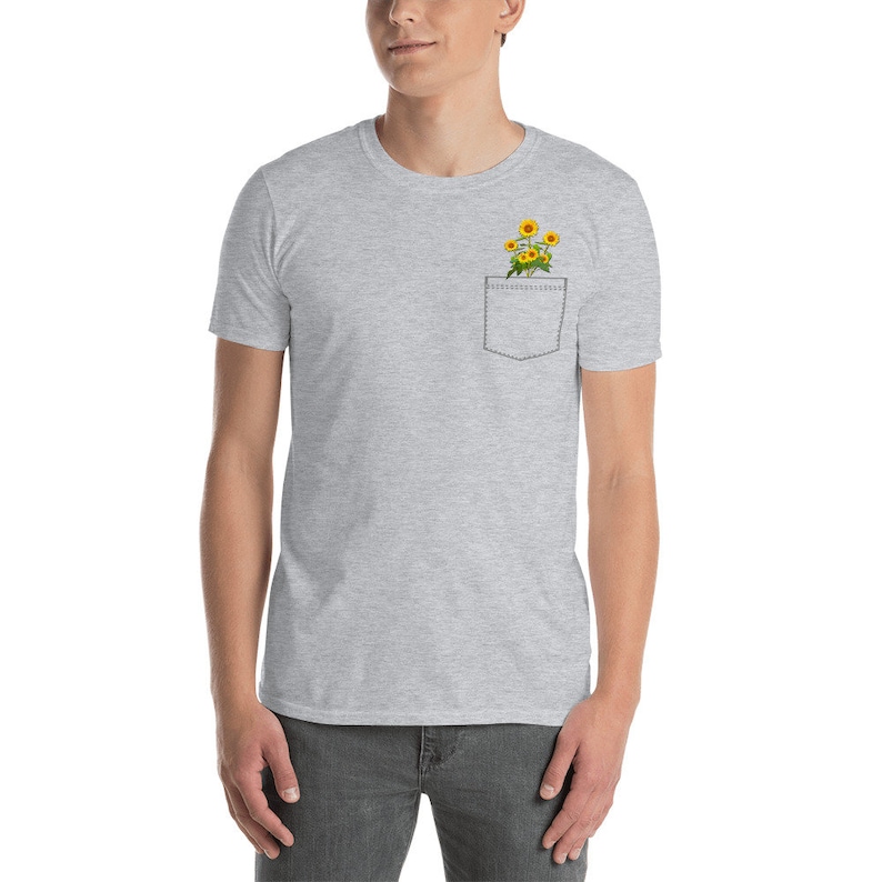 May include: A gray t-shirt with a pocket featuring a small bouquet of yellow sunflowers.