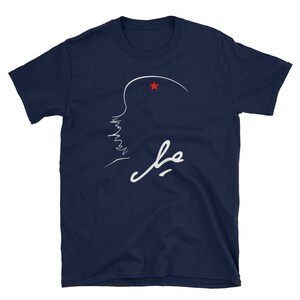 May include: A navy blue t-shirt with a white outline of a person's profile with a red star above their head. The word "Che" is written in white cursive below the profile.