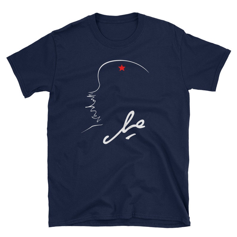May include: A navy blue t-shirt with a white outline of a person's profile with a red star above their head. The word "Che" is written in white cursive below the profile.