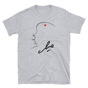 May include: A gray t-shirt with a black line drawing of a profile with a red star above it and the word "Che" written in black cursive.