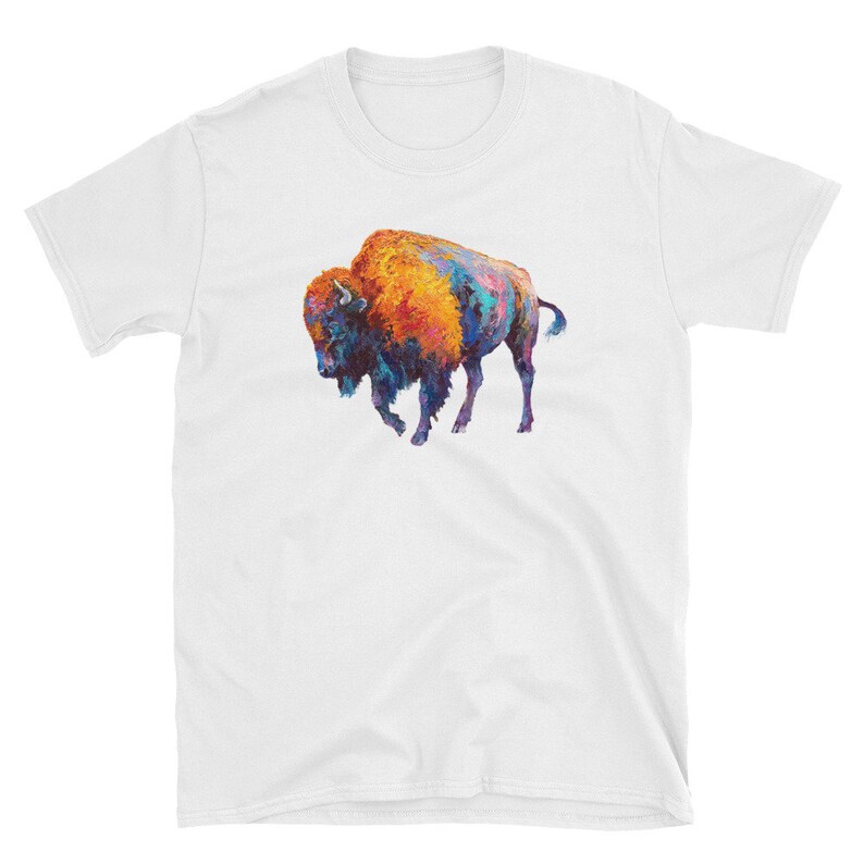 May include: A white t-shirt with a colorful painting of a bison on the front. The bison is painted in shades of orange, blue, and purple.