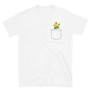 May include: White t-shirt with a pocket featuring a small bouquet of yellow sunflowers.