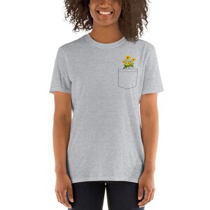 May include: A heather grey t-shirt with a pocket featuring a small bouquet of yellow sunflowers.