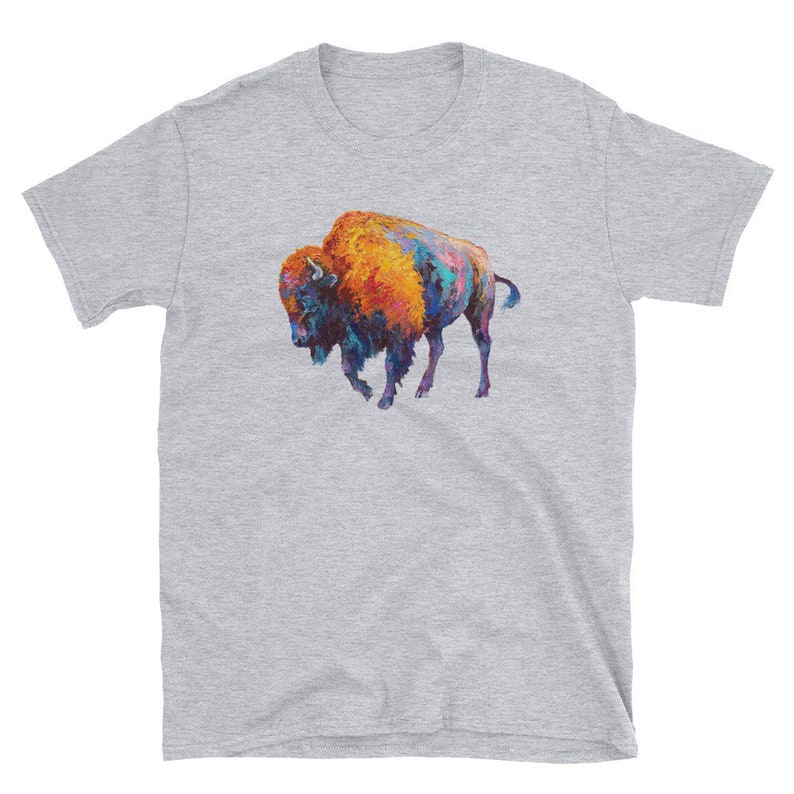 May include: A grey t-shirt with a colorful painting of a bison on the front. The bison is painted in shades of orange, blue, and purple.