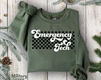 May include: A green sweatshirt with a white checkered background and the text "Emergency Tech" in a retro font.