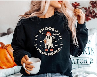 May include: Black sweatshirt with a graphic of a ghost wearing a red hat and holding a coffee cup. The text "Spooky Peds Nurse" is printed in white around the ghost.