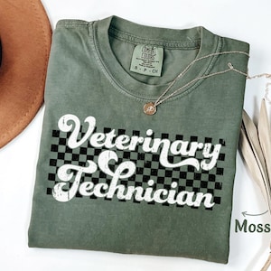 May include: A green t-shirt with the text "Veterinary Technician" in a retro font on a checkered background. The shirt is made of a soft, comfortable material and is perfect for everyday wear.