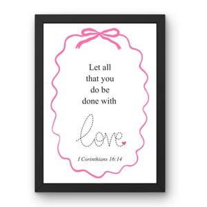 May include: Framed print with a black border. The white background features pink decorative elements, including a bow and a wavy border. The text reads "Let all that you do be done with love" and "I Corinthians 16:14".
