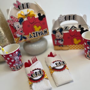 May include: Red and yellow Mickey Mouse and Minnie Mouse themed party favor boxes with the name "Aziyah" and the number "one" on them.  There are also red and yellow cups with polka dots and a Mickey Mouse and Minnie Mouse design.  There are also red and yellow napkins with a Mickey Mouse and Minnie Mouse design and the number "one" on them.