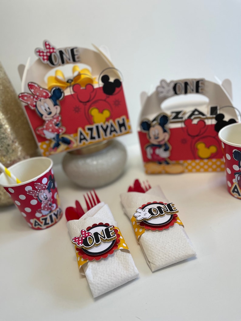 May include: Red and yellow Mickey Mouse and Minnie Mouse themed party favor boxes with the name "Aziyah" and the number "one" on them.  There are also red and yellow cups with polka dots and a Mickey Mouse and Minnie Mouse design.  There are also red and yellow napkins with a Mickey Mouse and Minnie Mouse design and the number "one" on them.