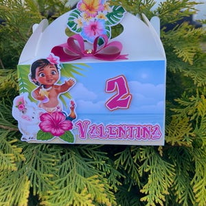 May include: A white gable box decorated with a cartoon image of a girl, a pig, and a pink number 2. The box is adorned with a pink bow and tropical flowers. The name "Valentina" is written on the box.