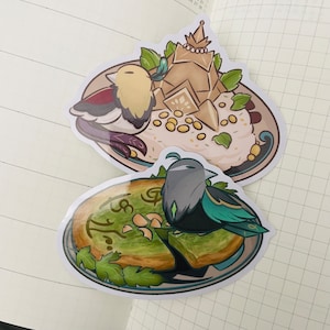 May include: Two stickers featuring a bird perched on a plate of food. The first sticker shows a bird with red, white, and yellow feathers perched on a plate of white rice with a golden crown on top. The second sticker shows a black and teal bird perched on a plate of green and brown food.