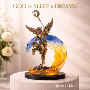 May include: A bronze-colored statue of the God of Sleep & Dreams, holding a lantern and staff with a crescent moon. The statue is 11.8 inches tall and features a blue and yellow wave design. The base is black.