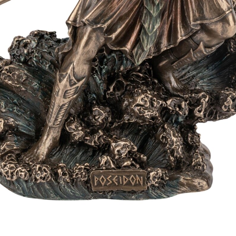 May include: Bronze-toned statue of Poseidon, the Greek god of the sea, standing on a textured base representing waves. The statue features intricate details in the clothing and armor, with the name "Poseidon" inscribed on the base.
