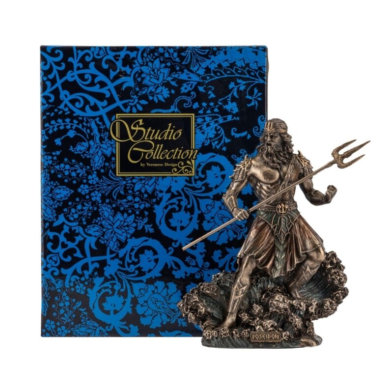 May include: A bronze-colored statue of Poseidon holding a trident, emerging from waves. The statue is next to a blue box with a floral design and the text "Studio Collection". The base of the statue has the word "Poseidon".