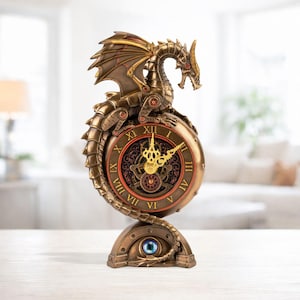 Könnte beinhalten: Eine bronzefarbene Drachenuhr im Steampunk-Stil. Die Uhr hat römische Ziffern, verzierte Zeiger und eine detaillierte Drachenskulptur. Der Sockel hat ein blaues augenförmiges Detail.