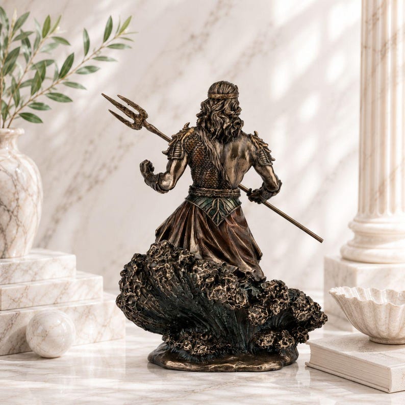 May include: Bronze-toned statue of a male figure, possibly a deity, holding a trident. The figure is depicted from the back, with long hair and a flowing robe, standing atop a sculpted wave base. The statue has intricate details and a weathered finish.