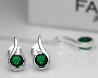 Puede incluir: Un par de pendientes de plata con una piedra preciosa verde en el centro de cada pendiente. Los pendientes tienen forma de lágrima.