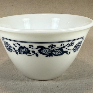 以下が含まれることがあります： 縁に青い花柄が施された白いセラミックボウル