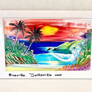 Könnte beinhalten: Ein gerahmtes Gemälde, das einen tropischen Sonnenuntergang mit Palmen, einem blauen Meer und Delfinen zeigt, die in den Wellen springen. Das Gemälde ist signiert mit "Puerto Vallarta 2003".