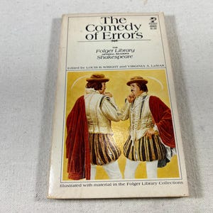 May include: A book cover for "The Comedy of Errors" by William Shakespeare. The cover features a red, white, and black illustration of two men in Renaissance-era clothing.