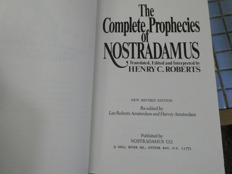 Puede incluir: Libro abierto con el t&iacute;tulo "The Complete Prophecies of Nostradamus" en fuente grande y elegante. El texto incluye el nombre del traductor, "HENRY C. ROBERTS", y detalles sobre la edici&oacute;n revisada y la editorial, NOSTRADAMUS CO.