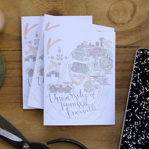 May include: A stack of white cards with a hand-drawn map of the University of Tennessee Knoxville. The map is in black and white with some color accents. The text "University of Tennessee Knoxville" is written in cursive at the bottom of the map.