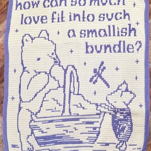 May include: A crocheted blanket with a purple border and a white background. The blanket features a purple illustration of a bear sitting in a tub with a dragonfly flying above. The text "how can so much, love fit into such a smallish bundle?" is written in purple on the blanket.