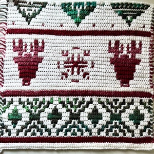 May include: White crochet blanket with a red and green winter theme. The blanket features a snowflake and two reindeer designs.