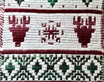 May include: White crochet blanket with a red and green winter theme. The blanket features a snowflake and two reindeer designs.