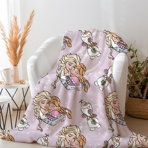 Pu&ograve; includere: Una coperta in pile rosa con un motivo ripetuto di due sorelle che si abbracciano e un pupazzo di neve che tiene una rosa. Le sorelle hanno i capelli lunghi e biondi e indossano abiti blu e rosa. Il pupazzo di neve &egrave; bianco con un naso di carota e occhi neri.