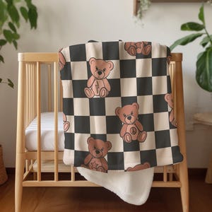 Pu&ograve; includere: Una copertina per neonati a scacchi bianchi e neri con un motivo di orsacchiotto di peluche marrone. La copertina &egrave; morbida e coccolona, perfetta per una cameretta o una sala giochi.