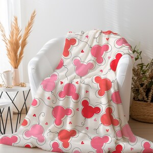 May include: A white fleece throw blanket with a pink and red Mickey Mouse head balloon pattern.