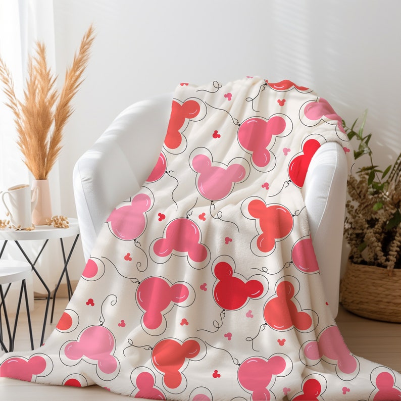May include: A white fleece throw blanket with a pink and red Mickey Mouse head balloon pattern.