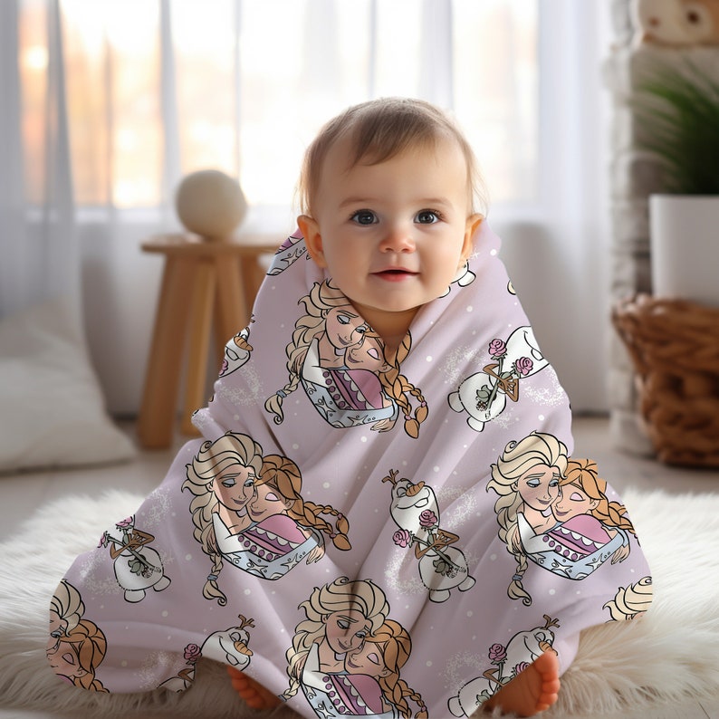Pu&ograve; includere: Una morbida coperta per neonati rosa con un motivo ripetitivo di Elsa e Anna di Frozen che si abbracciano, e Olaf il pupazzo di neve che tiene una rosa.